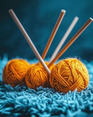 Poster - Cozy Still Life of Golden Yarn Balls and Knitting Needles on Soft Blue Rug in Warm Light