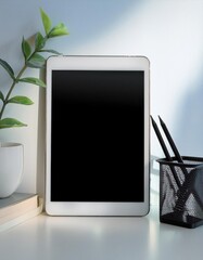 Poster - Tablet Resting on a Clean White Desk Surrounded by Green Plants and Stationery in the Morning Light