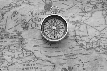 classic round compass on background of old vintage map of world