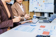 © Phushutter - Two female business professionals in suits sit at desk, engaged in strategic discussion. They analyze financial planning, risk management, corporate growth while reviewing reports and market trends.