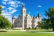 Majestic Stone Courthouse Surrounded by Lush Greenery Under Bright Blue Sky