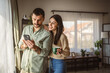 © Miljan Živković - adult couple boyfriend and girlfriend use mobile phone for fun at home