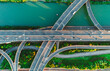 © Evgenii Bakhchev - Aerial of vehicles navigate a complex highway system, showcasing overpasses and intersections.