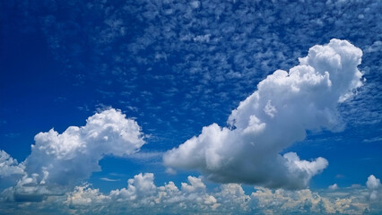 Wall Mural - Majestic Cumulus Clouds Against a Deep Blue Sky Over a Scenic Landscape