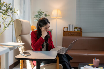 Poster - Asian businesswoman working from home sitting on armchair using laptop looking concerned