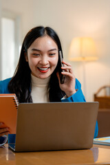 Poster - Smiling businesswoman working from home, talking on mobile phone and using laptop, holding notebook