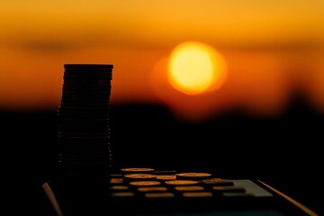 Poster - a stack of coins is on top of a calculator. the image has a mood of financial security and stability