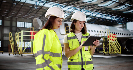 Fototapete - The woman in the hangar checks the jet engine with precision.