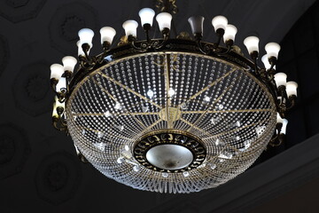 Poster - A traditional chandelier with a working clock at its top, suitable for interior design or home decor images.