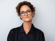 © Chari - Confident woman with glasses smiling against a plain background in a modern setting