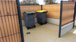 © Esta Webster - deux bacs de poubelles pour déchets ménagers et tri sélectif dans un box extérieur