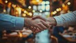 © BOYZONEPHOTO - Handshake Between Two People in a Cozy Cafe Setting with Warm Ambient Lighting
