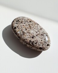 Poster - Smooth Oval Stone on Light Surface with Subtle Texture Variations