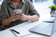 © MIND AND I - Businesswoman sitting at desk on couch in workplace or at home working on laptop and analyzing data on charts and graphs and writing on papers to make business plan and strategies for company,