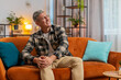 © Andrii Iemelianenko - Caucasian man suffer from painful discomfort severe knee joint ache, leg muscles, could not walk. Sick guy with gray hair massaging knees illness cramps rheumatism on sofa couch. Health care problem