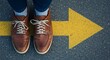 © DhanaStudio - Leather shoes on a yellow painted arrow - direction and guidance - for travel blogs