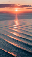 Poster - Orange sunset reflecting on ocean waves, creating a textured pattern of light and shadow, showcasing serenity and calm, ideal for peaceful themes