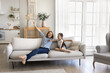 © fizkes - Celebrate new beginning. Excited young mom little child daughter rest on sofa at modern comfortable home interior after relocation spread arms wide relax in comfort enjoy freedom in new living space