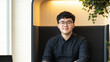 © Andreas - Confident Young Man with Glasses Working in a Modern Office