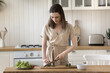 © fizkes - Fresh start of day. Happy young woman enjoy home cooking prepare healthy vegetarian food for breakfast cut summer seasonal ingredients for nutritious dietary vegetable salad on domestic kitchen table