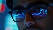 © Johannes - Young indian business man trader wearing glasses looking at computer screen with trading charts reflecting in eyeglasses watching stock trading market financial data growth concept, close up.