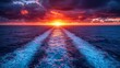 © Wall - A view of the sun setting over the ocean from the back of a boat