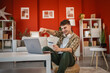 © Miljan Živković - young man enjoy at online shopping with credit card and laptop at home