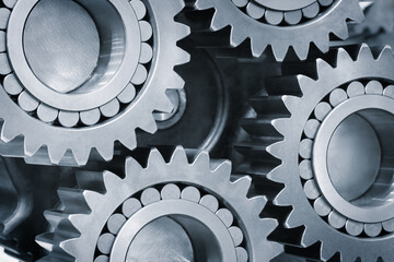Poster - A close up of three gears with a lot of detail. The gears are all different sizes and are all connected to each other. Concept of complexity and precision, as the gears are all intricately designed