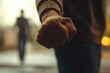 © sun - Clenched Fist Symbolizing Domestic Violence and Emotional Turmoil with Woman in Background
