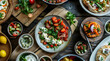 © Maya Crafta - Overhead View of Colorful Mediterranean Mezze Platter Featuring Salad and Various Dishes on Weathered Wooden Surface Creating Inviting Food Presentation