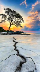 Wall Mural - a solitary tree stands against a vibrant sunset, casting shadows on cracked earth by the water's edg