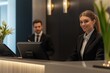 © Marina Varnava - Professional hotel receptionist assists guest at modern desk with digital equipment in a polished environment