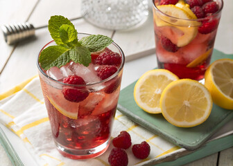 Poster - A refreshing beverage made from raspberries and lemon is featured in the image, served in two glasses with ice.