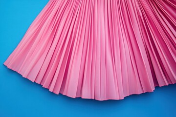 Leinwandbilder - Pleated pink fabric drapes elegantly against a vibrant blue background, showcasing texture and color contrast in a minimalist style
