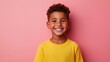 © Nat_Photo_AI - Joyful Young Boy Smiling with Curly Hair Against a Bright Pink Background in a Casual Yellow T-Shirt