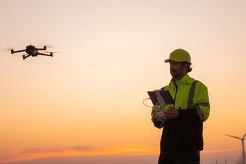 Aufkleber - Engineers male flying drone surveying and checking wind turbines from the high angle view of the field during beautiful sunset. using drone technology for work.