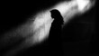 © Anastasia - Black and white photograph of a person standing in a dark room. the person is facing away from the camera, with their head turned towards the right side of the image.