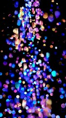 Poster - Enchanting cascade of colorful bokeh lights in motion against a dark background