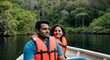 © Anna - Smiling Indian couple wearing life jackets enjoying a boat ride in a lush jungle river