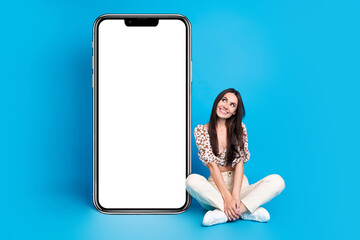 Poster - Full size photo of pretty young woman look empty space smart phone display isolated on blue color background