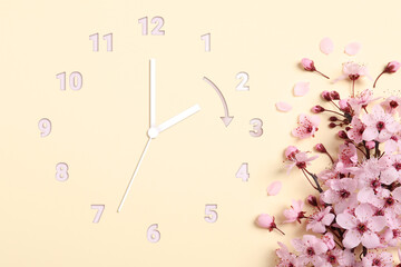 Poster - Clock and blossoming branch with pink flowers on beige background, top view. Arrow showing time change one hour ahead in spring. Daylight saving time