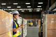 © KPs Photography  - Worker conducts inventory check in warehouse with safety gear in bright industrial environment during daytime shift