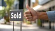 © rajagambar99 - Hand Giving Thumbs Up Next to Sold Sign on Property