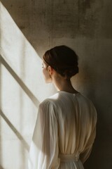 Poster - A woman in a white dress stands by the window, looking outside