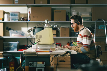 Happy geek guy playing videogames with a vintage PC