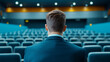 © Fareedoh - man in suit sits in empty auditorium, reflecting on possibilities