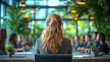 © D-stock photo - Rear view of young businesswoman sitting at table in office and looking away