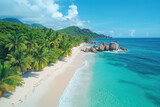 Crystal clear waters sparkle under a vibrant blue sky at the Seychelles Islands beach. Palm trees sway on the white sandy shore, inviting relaxation and tranquility.