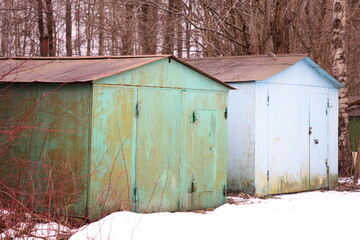 Poster - Two small cabins situated closely together amidst snow-covered landscape.