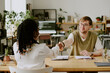 © AnnaStills - Back view of African American woman in smart clothes shaking hands with professional male hiring manager after successful job interview